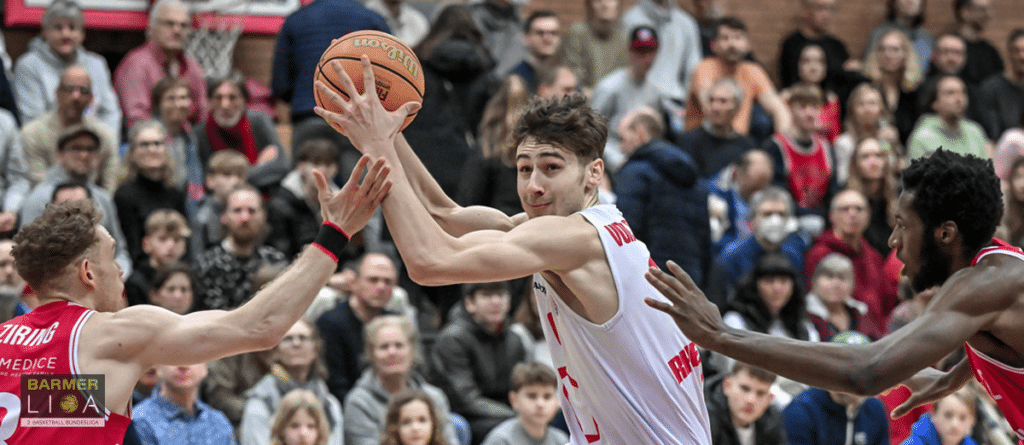 Basketballspieler der RheinStars Köln wirft Ball über Gegenspieler hinweg.