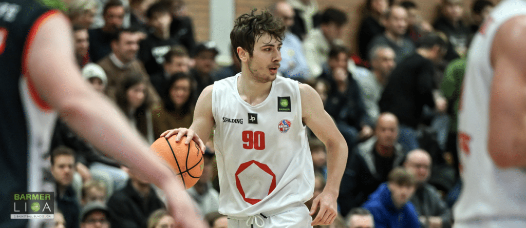 Basketballspieler der RheinStars Köln mit Nummer 90 dribbelt den Ball während eines Heimspiels.