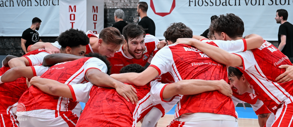 Mannschaft der RheinStars Köln umarmt sich jubelnd nach einem Sieg.