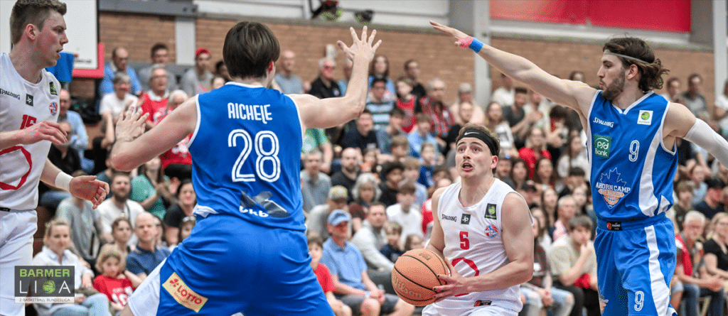 Basketballspiel der RheinStars Köln gegen blaues Team in voller Halle.