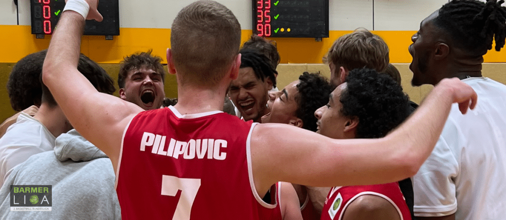 Basketballteam der RheinStars Köln jubelt nach Spielsieg in der Halle.