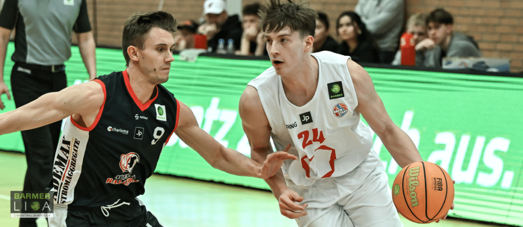 Basketballspiel: Spieler der RheinStars Köln (weiß, Nummer 24) dribbelt gegen Verteidiger in schwarzem Trikot.