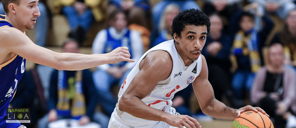Basketballspieler der RheinStars Köln dribbelt mit Ball gegen Verteidiger.