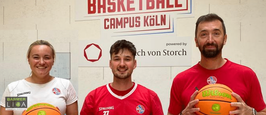 Drei Basketballer der RheinStars Köln posieren mit Basketbällen vor dem Campus Köln Logo.