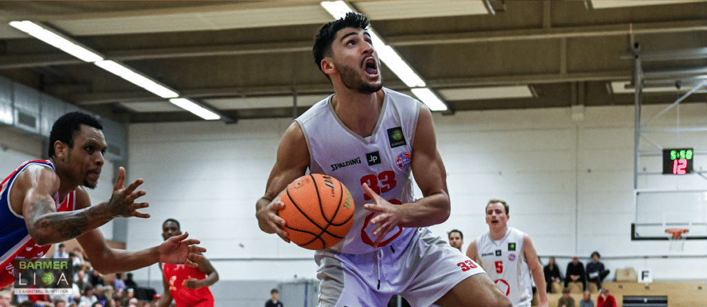 Basketballspieler der RheinStars Köln mit Nummer 39 dribbelt den Ball in der Halle.
