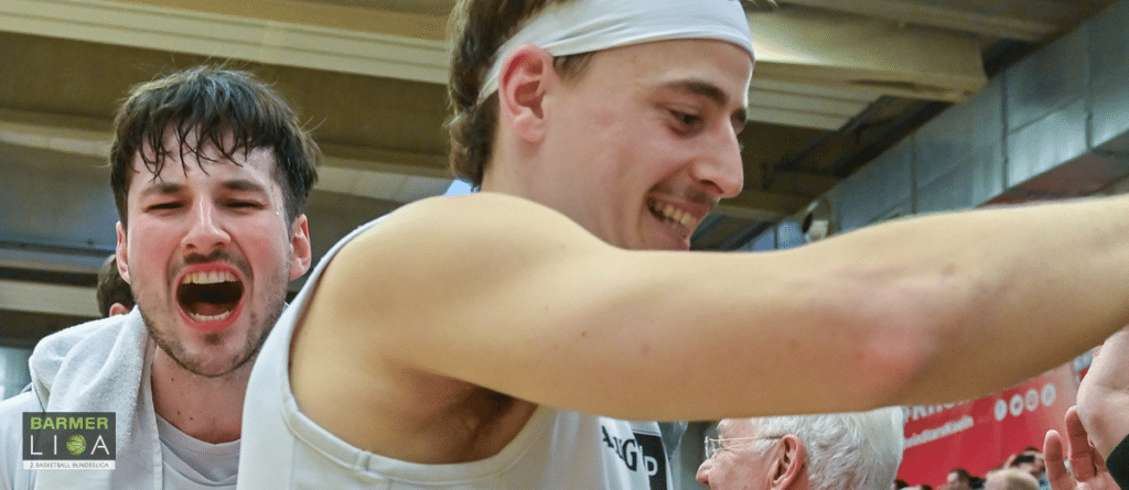 Zwei jubelnde Spieler der RheinStars Köln beim Basketball-Training in der Halle.