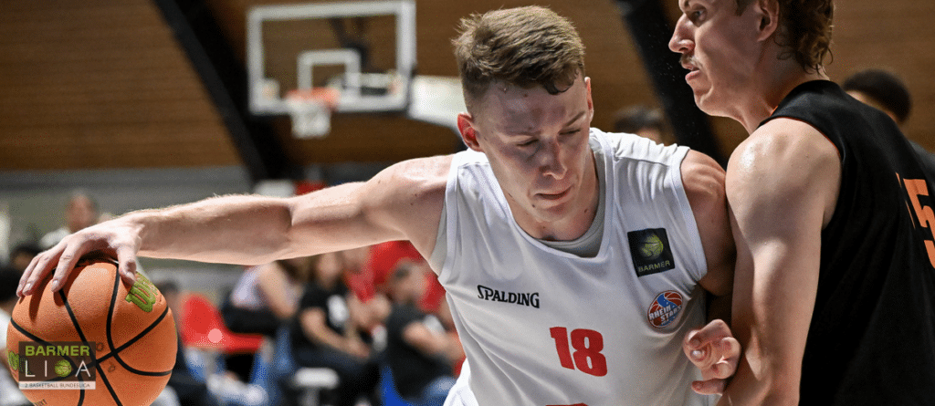 Basketballspieler der RheinStars Köln in weißem Trikot mit der Nummer 18 dribbelt den Ball während eines Spiels.