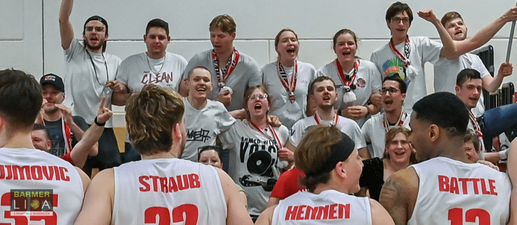 RheinStars Köln Basketballteam feiert Sieg mit Fans in Sporthalle.