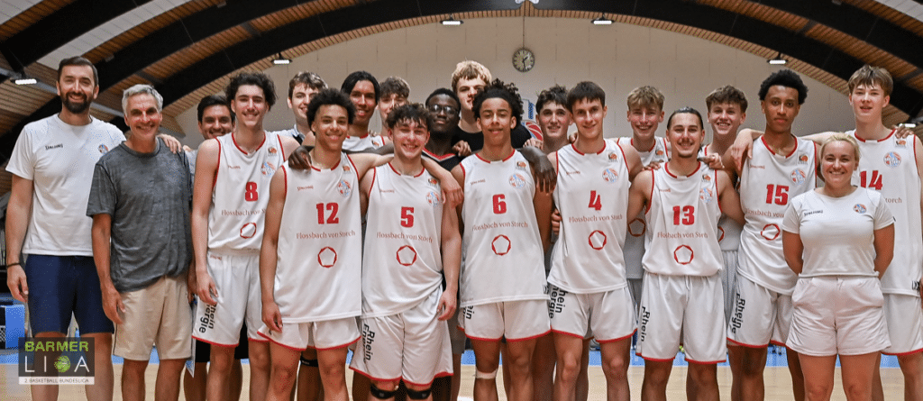 Mannschaftsfoto der RheinStars Köln Basketballmannschaft in weißen Trikots in einer Sporthalle.