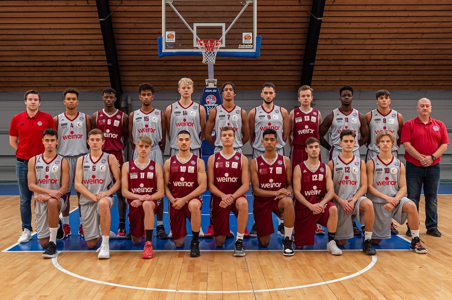 Mannschaftsfoto der RheinStars Köln Basketball-Jugendmannschaft in einer Sporthalle.