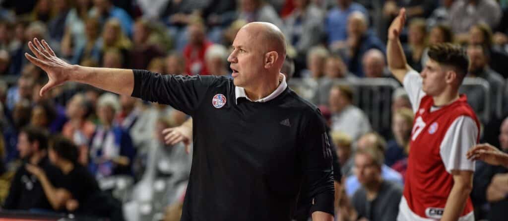Ein Trainer der RheinStars Köln gestikuliert anweisend während eines Basketballspiels vor Zuschauern.