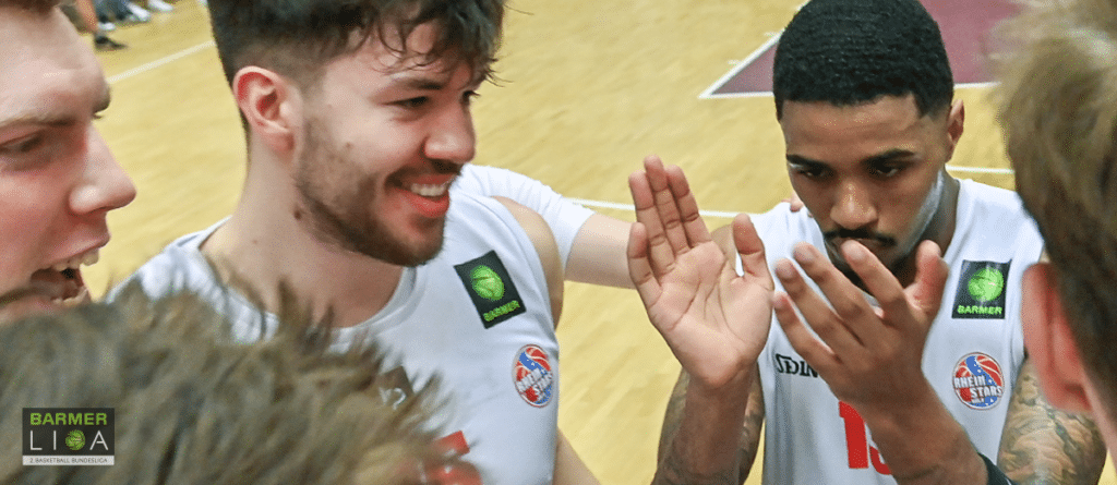 Spieler der RheinStars Köln jubeln zusammen auf dem Basketballplatz.