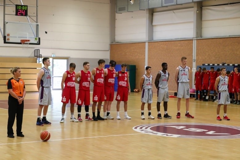 Basketballmannschaften der RheinStars Köln stehen sich in einer Sporthalle gegenüber.