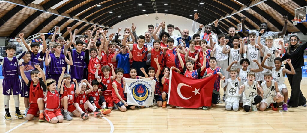 Gruppenfoto von Basketballteams in einer Sporthalle mit türkischer Flagge und RheinStars-Köln-Banner.