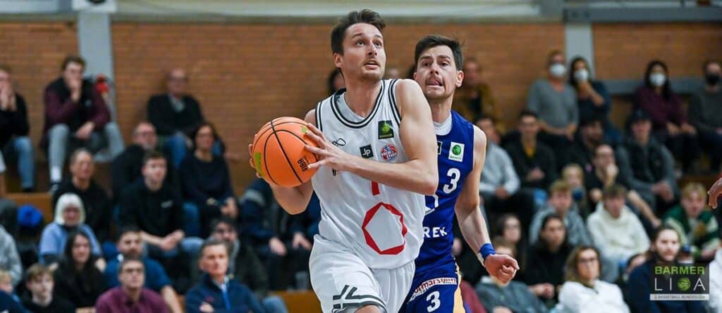Basketballspieler der RheinStars Köln dribbelt Ball während Heimspiel vor Publikum.
