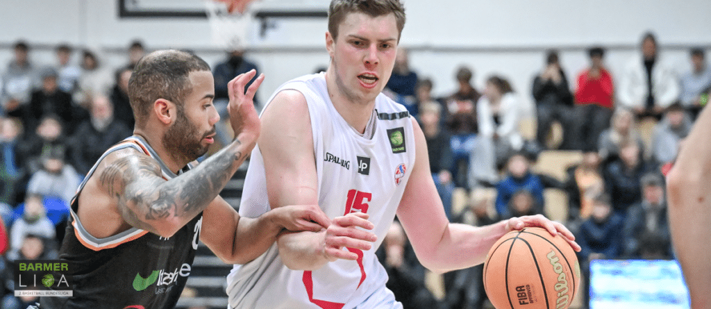 Basketballspieler der RheinStars Köln mit Nummer 15 dribbelt gegen Verteidiger.