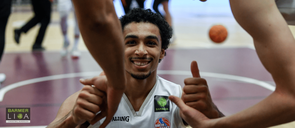 Basketballspieler der RheinStars Köln zeigt lächelnd Daumen hoch.